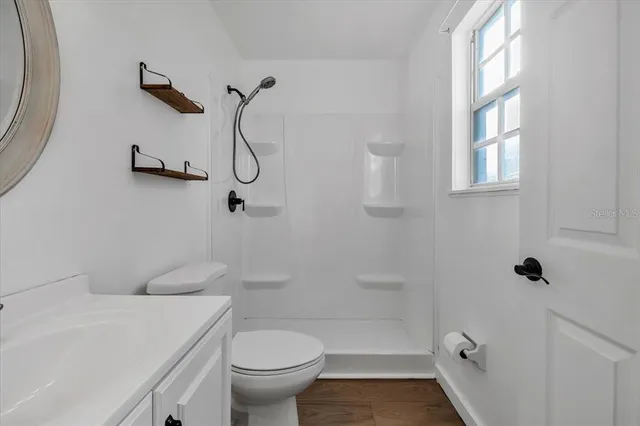 a bathroom with a shower a toilet and a sink