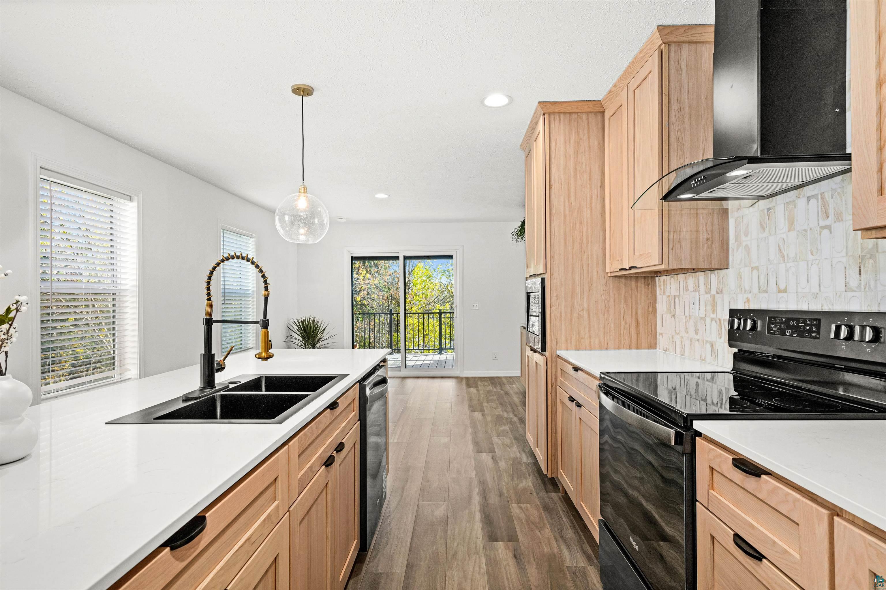 1914 East 1st Street Duluth, MN 55812 - Photo 13 of 26 Kitchen featuring stainless steel appliances, range with cooktop, light Elm/Oak wood finish cabinets, and light stone- Willow White Quartz countertops.