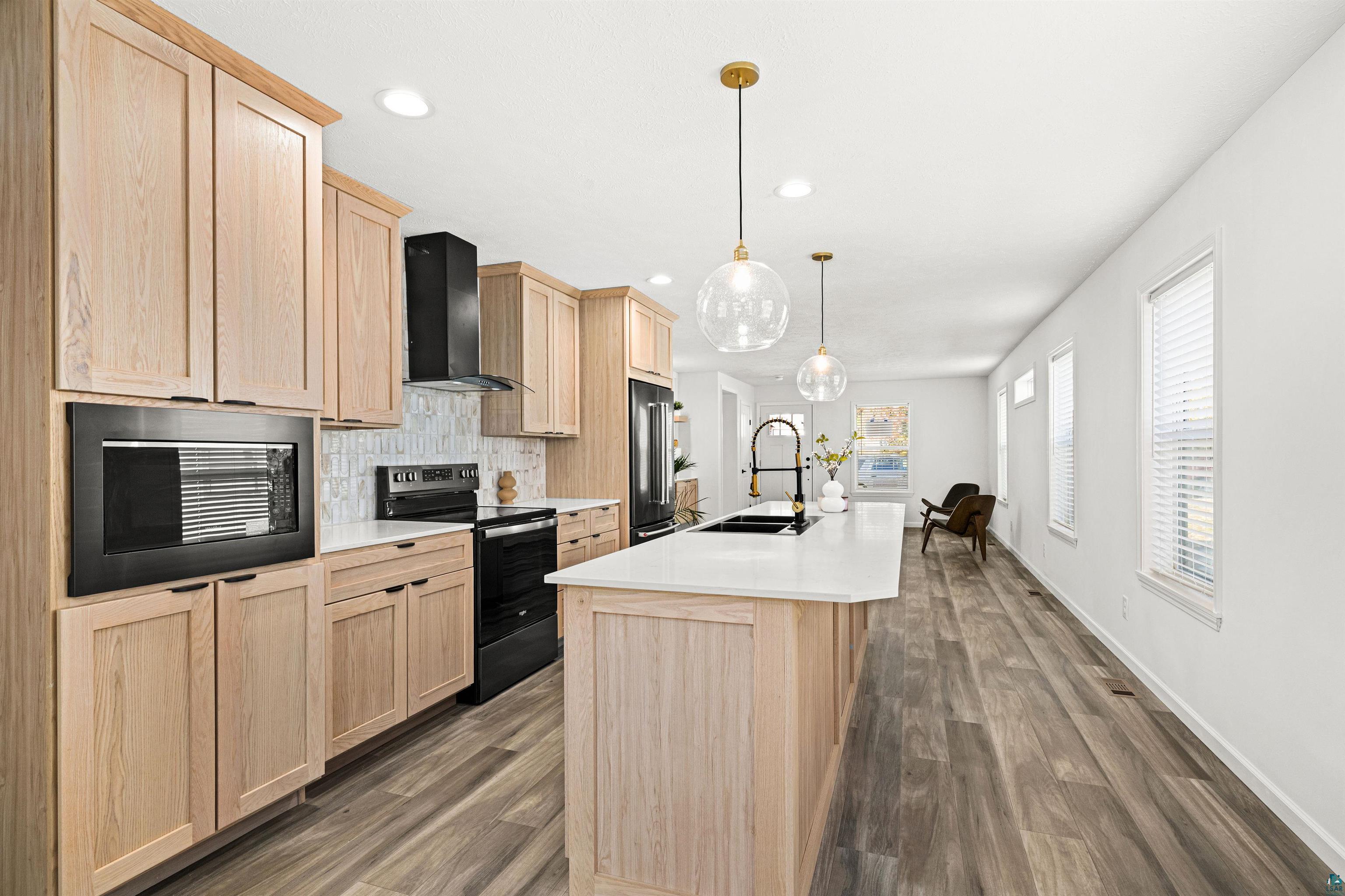 1914 East 1st Street Duluth, MN 55812 - Photo 14 of 26 Kitchen with light wood finish cabinets, electric range, a kitchen island with sink, & Willow White Quartz counter tops.