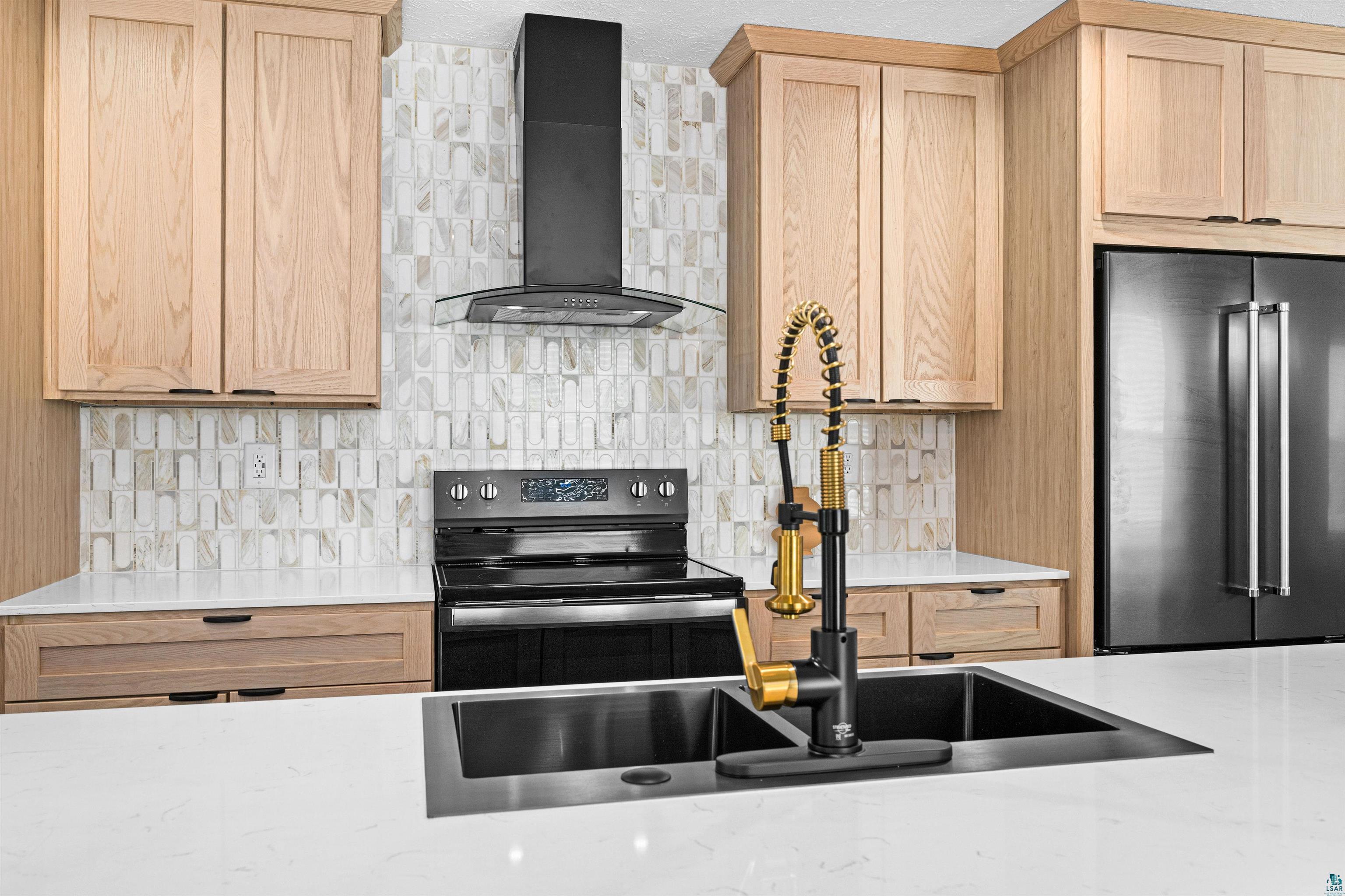 1914 East 1st Street Duluth, MN 55812 - Photo 15 of 26 Kitchen w/large island & featuring electric range, high quality fridge, light wood finish cabinets, tasteful designed backsplash, and Willow White Quartz counter tops.