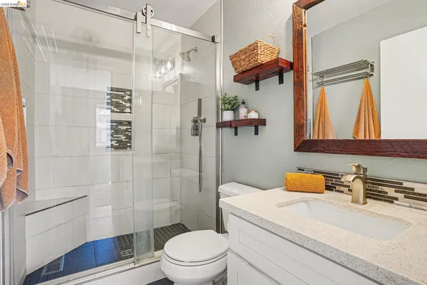 a bathroom with a sink a toilet and shower