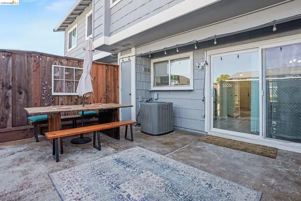 a backyard of a house with barbeque oven table and chairs