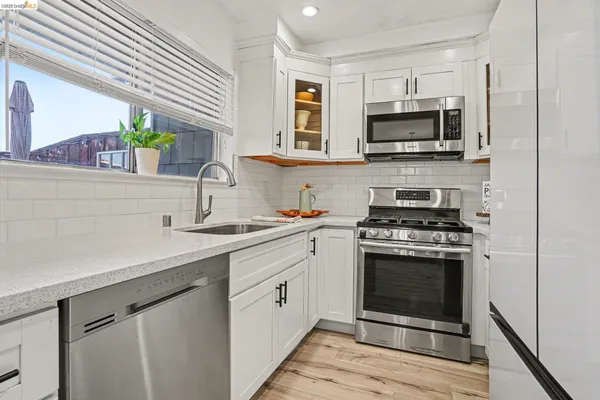 a kitchen with stainless steel appliances a stove microwave and sink