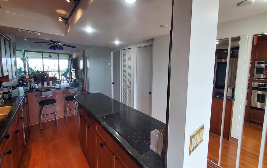 9415 Blind Pass Road, Unit 905 St. Pete Beach, FL 33706 - Photo 12 of 51 a kitchen with stainless steel appliances granite countertop sink stove refrigerator and wooden floor