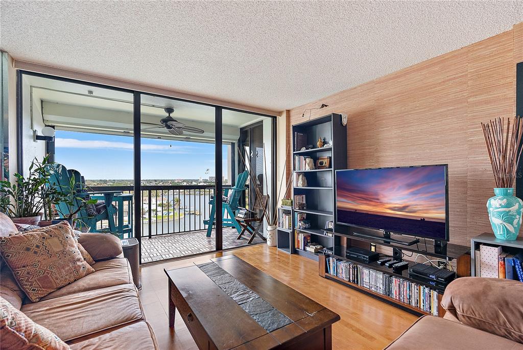 9415 Blind Pass Road, Unit 905 St. Pete Beach, FL 33706 - Photo 17 of 51 a living room with furniture and a flat screen tv