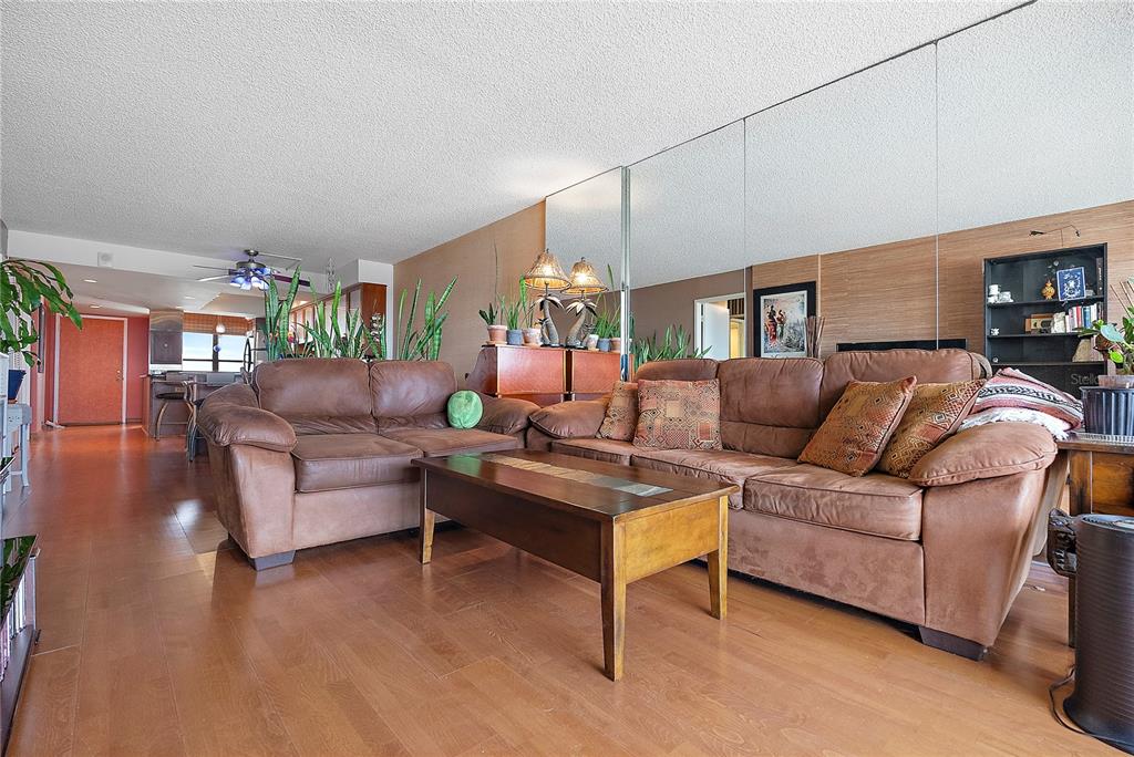 9415 Blind Pass Road, Unit 905 St. Pete Beach, FL 33706 - Photo 18 of 51 a living room with furniture a chandelier and a dining table