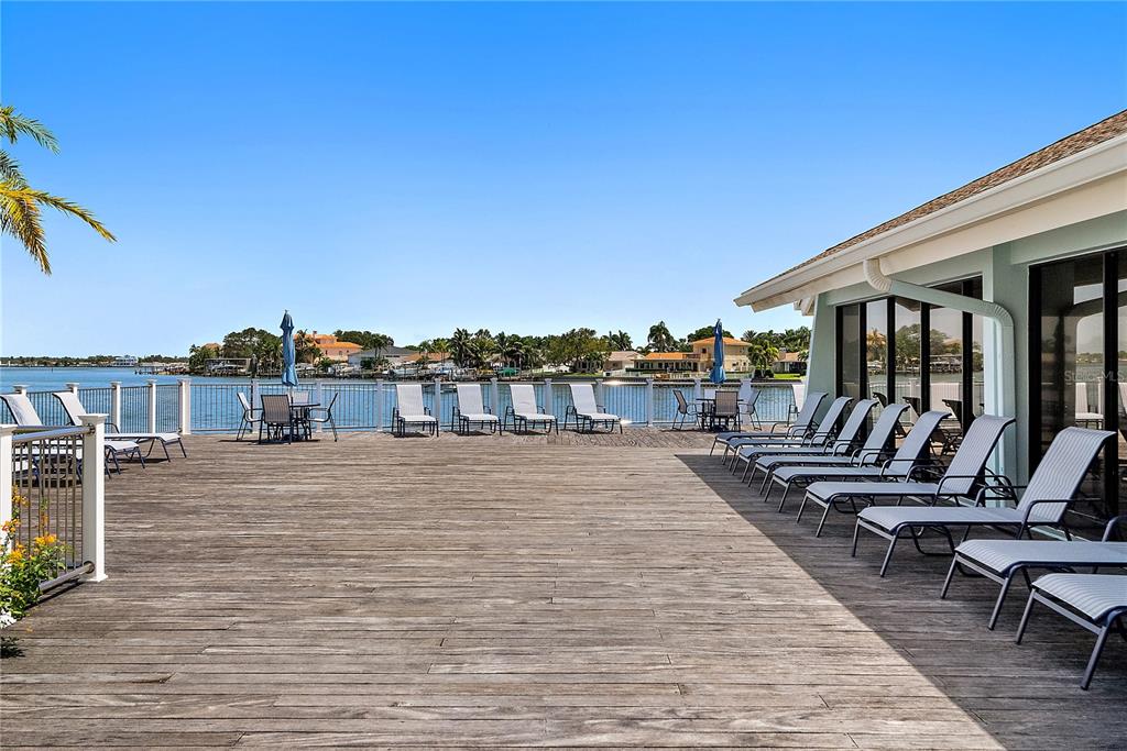 9415 Blind Pass Road, Unit 905 St. Pete Beach, FL 33706 - Photo 34 of 51 a swimming pool with outdoor seating and yard