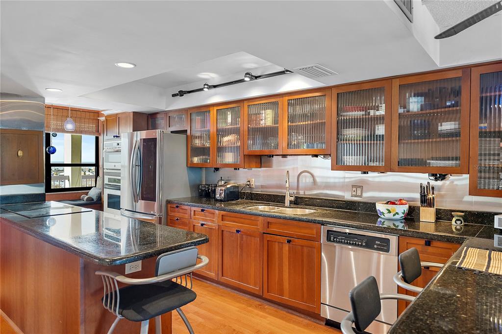 9415 Blind Pass Road, Unit 905 St. Pete Beach, FL 33706 - Photo 8 of 51 a kitchen with stainless steel appliances granite countertop a stove a sink and a refrigerator