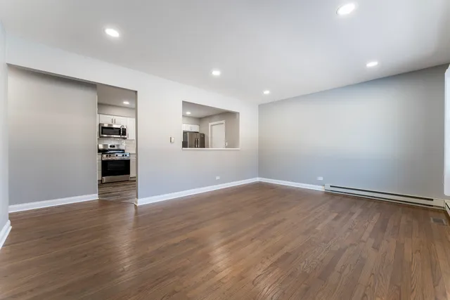 an empty room with wooden floor and entrance