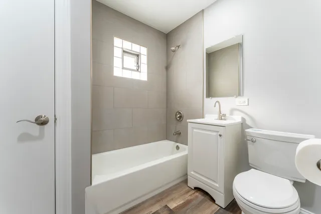 a bathroom with a toilet a sink a mirror and bathtub