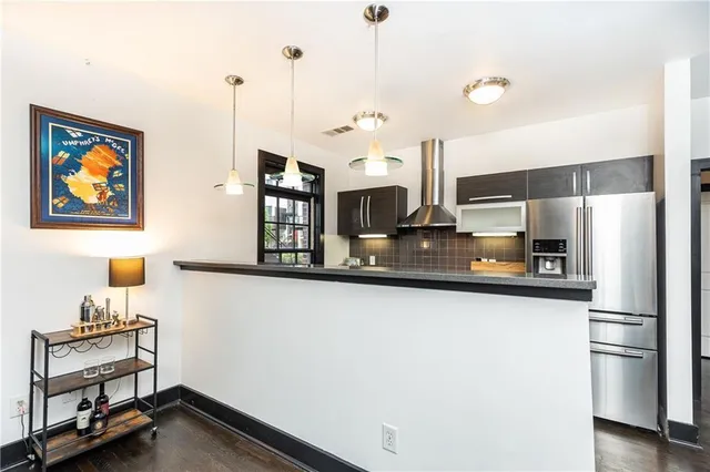 a kitchen with stainless steel appliances a refrigerator and a stove top oven