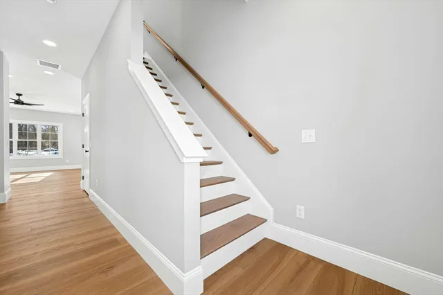 a view of a hallway with wooden floor and staircase