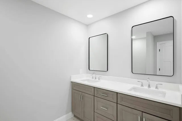 a bathroom with a double vanity sink and a mirror