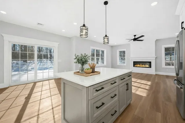 a hallway with a stove a faucet a chandelier and living room view