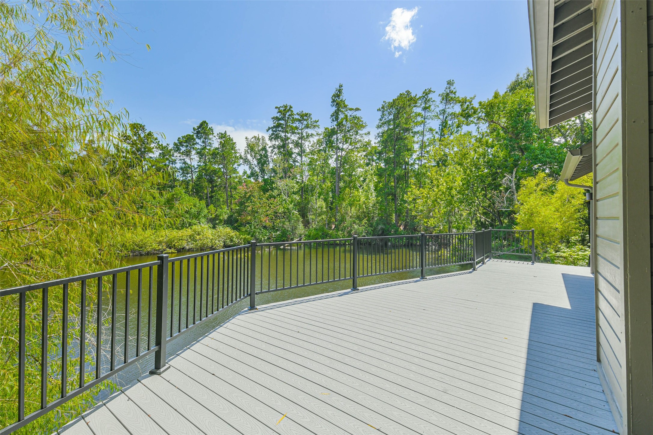 88 Raccoon Ramble Cleveland, TX 77327 - Photo 36 of 43 Expansive deck with serene water views, surrounded by lush greenery for a peaceful outdoor retreat.
