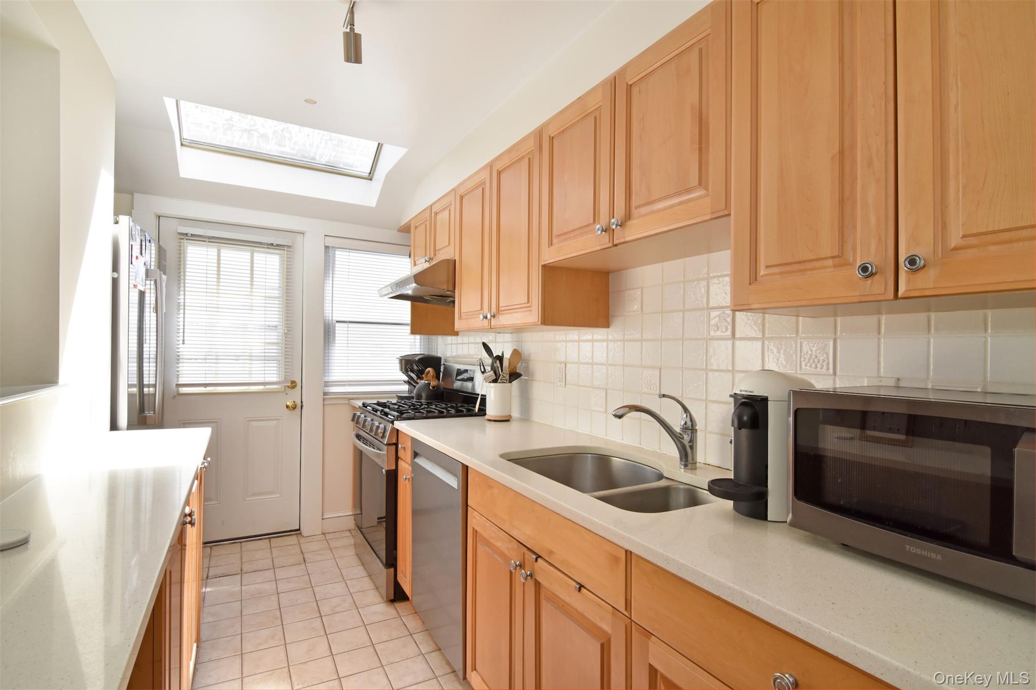 74 Kensington Road Bronxville, NY 10708 - Photo 14 of 33 a kitchen with stainless steel appliances granite countertop a sink and a stove