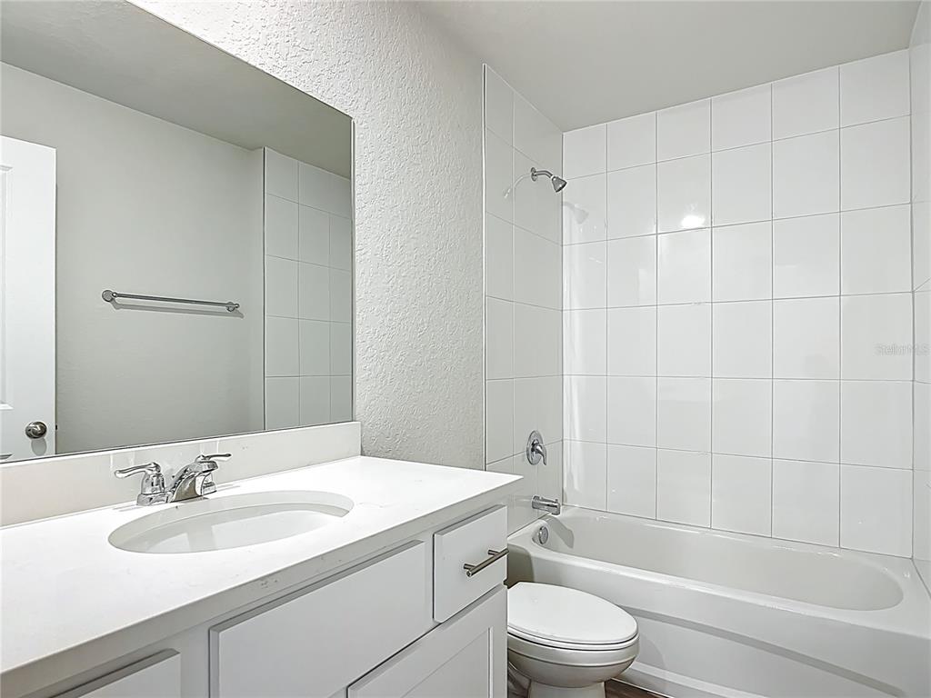 111 East Harvard Street Inverness, FL 34452 - Photo 17 of 21 a bathroom with a granite countertop sink toilet a mirror and shower