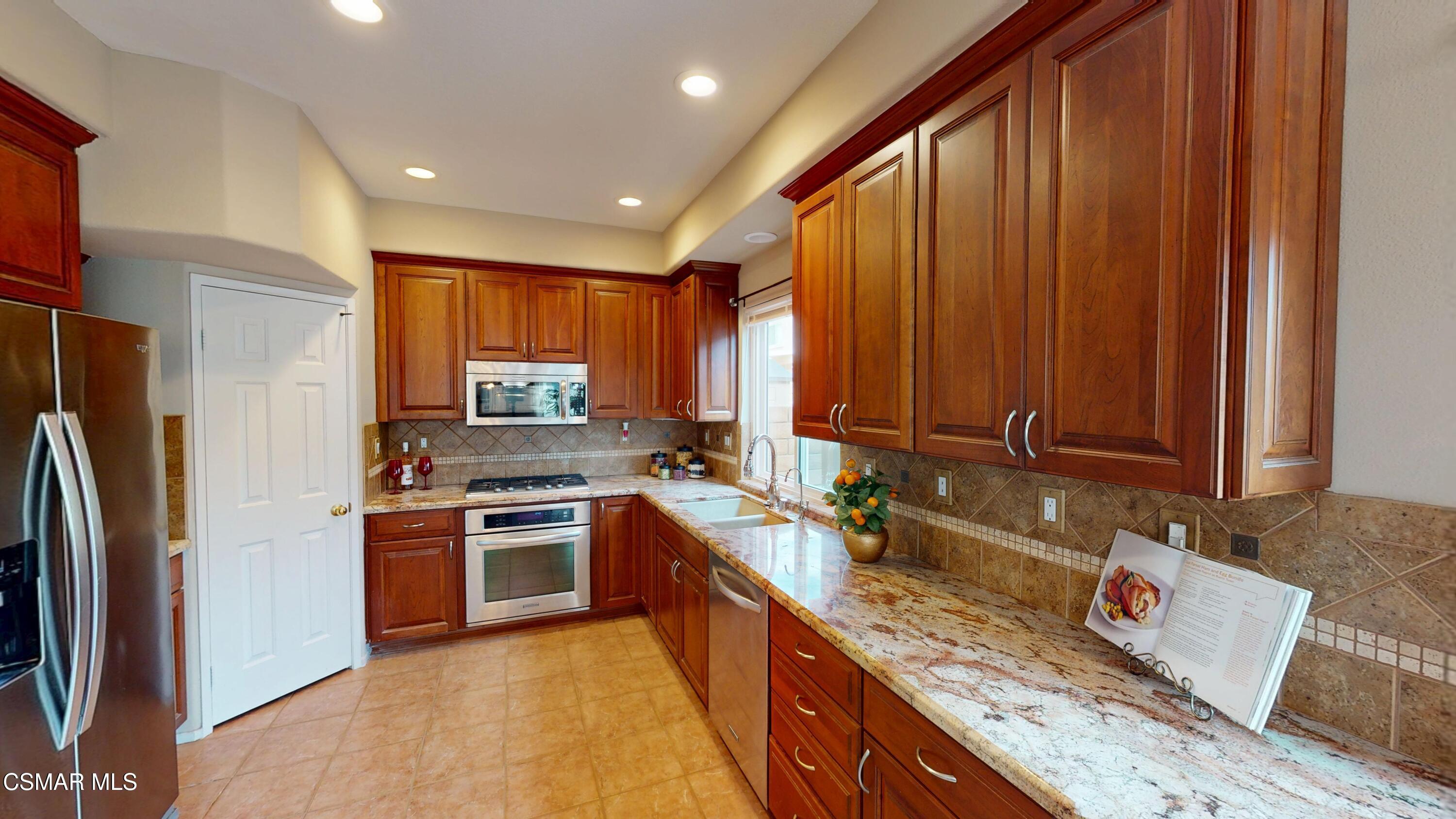 1708 Starpine Way Simi Valley, CA 93065 - Photo 22 of 60 a kitchen with stainless steel appliances granite countertop wooden cabinets a stove top oven a sink and dishwasher