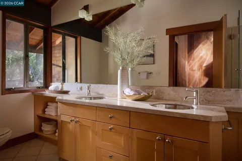 a front view of a house with garden and trees