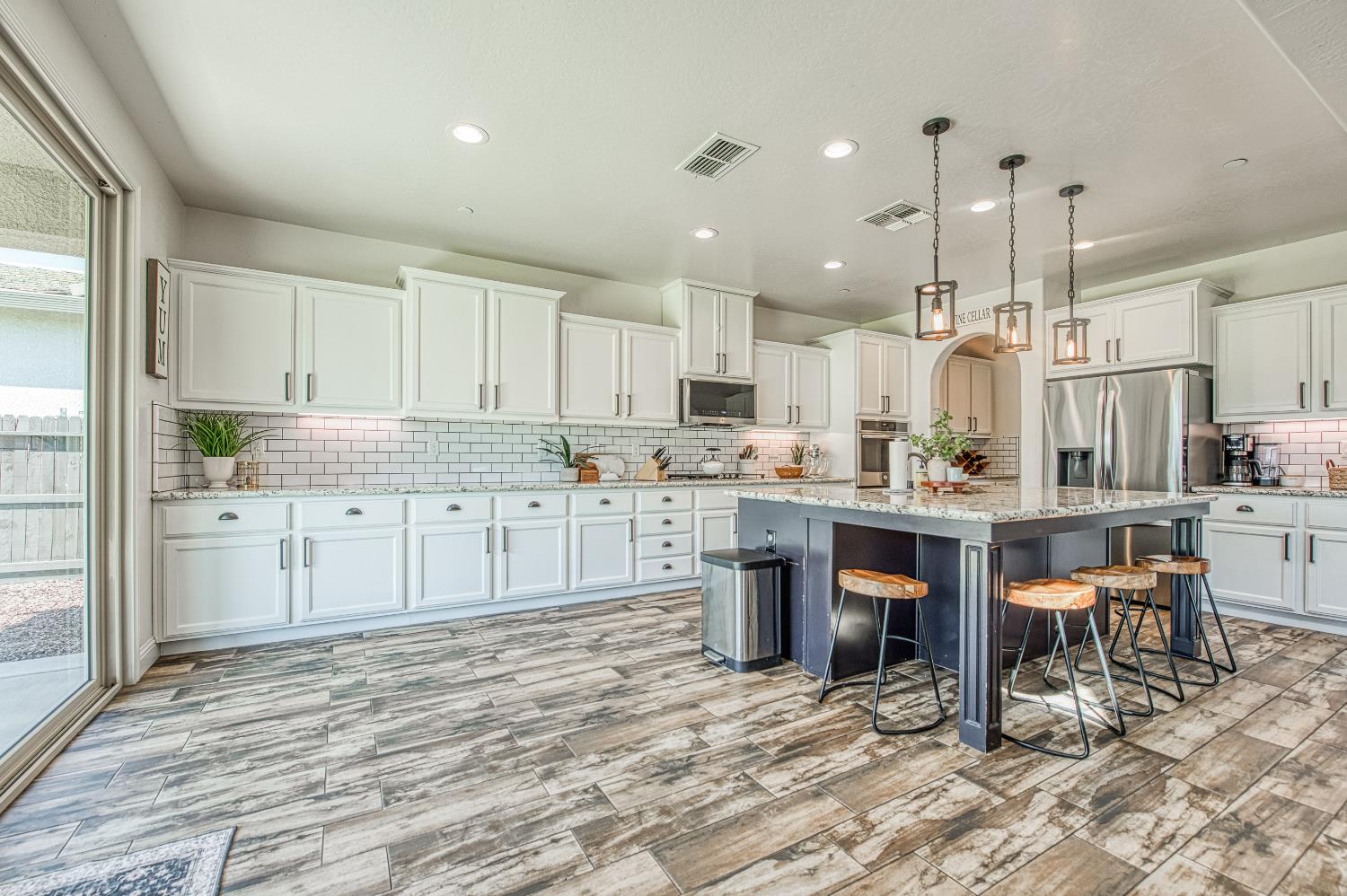 753 East Aretha Avenue Fowler, CA 93625 - Photo 17 of 61 a kitchen with stainless steel appliances kitchen island granite countertop a table chairs sink and cabinets