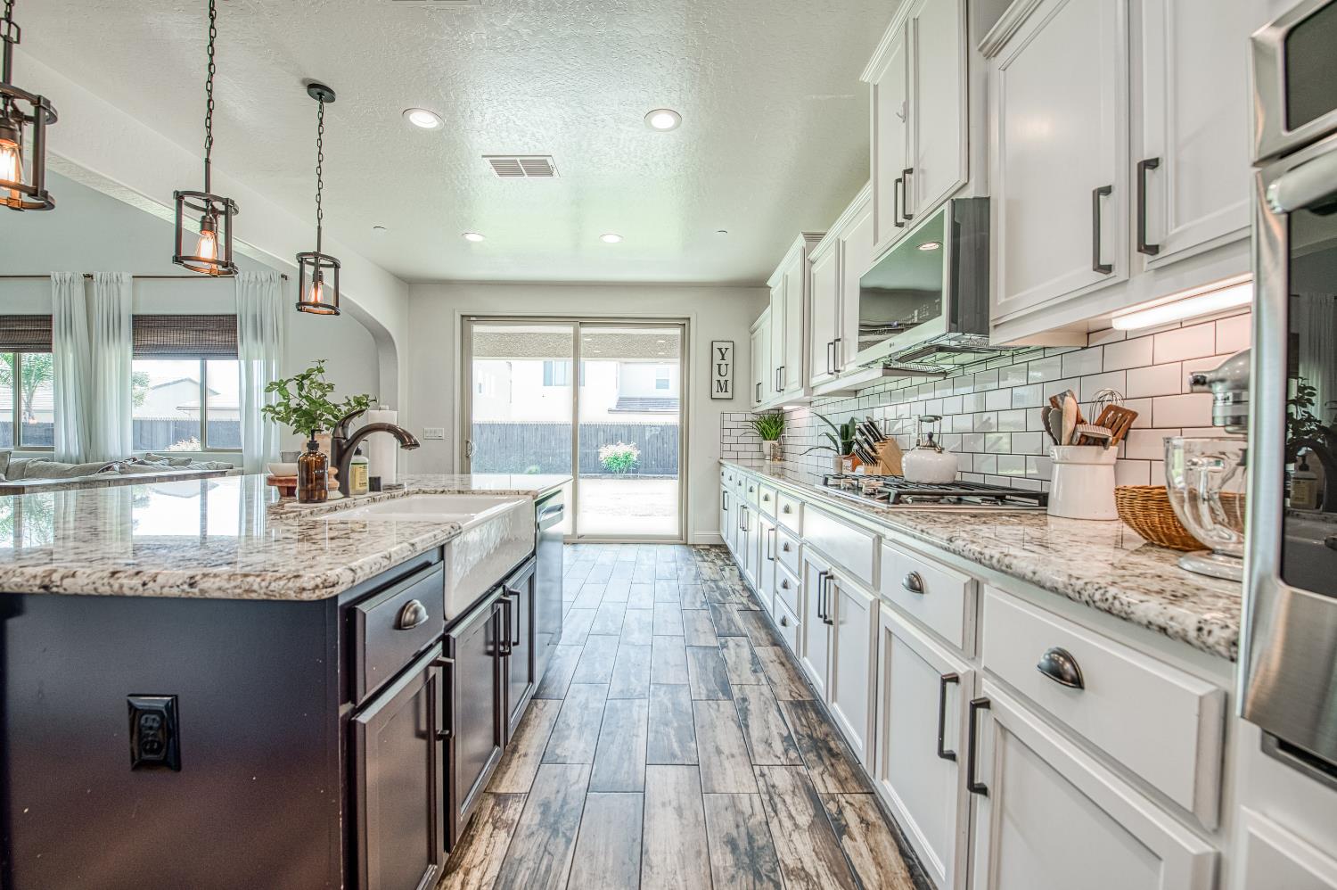 753 East Aretha Avenue Fowler, CA 93625 - Photo 20 of 61 a kitchen with stainless steel appliances granite countertop a sink dishwasher a stove and white cabinets next to a window