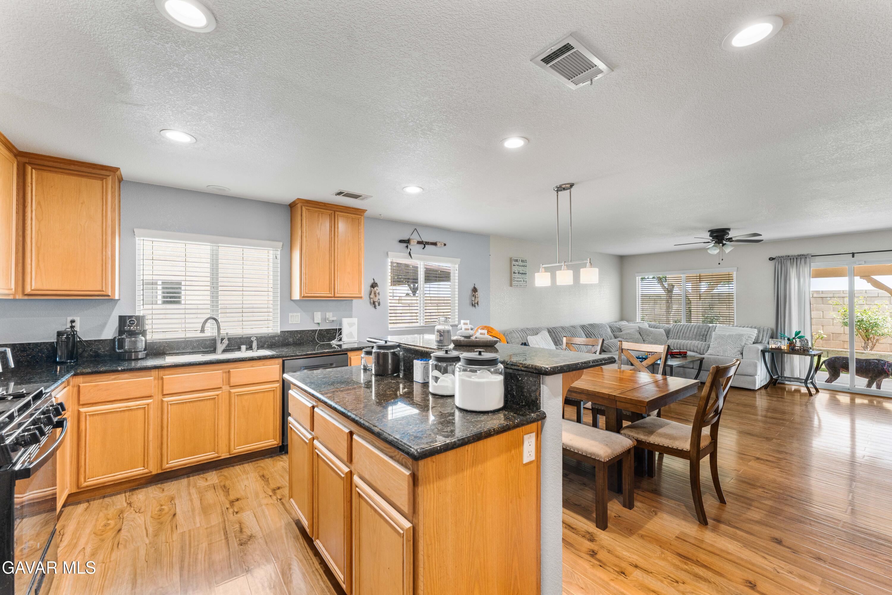 45448 Spahn Lane Lancaster, CA 93535 - Photo 12 of 49 a kitchen with granite countertop a sink stove and cabinets
