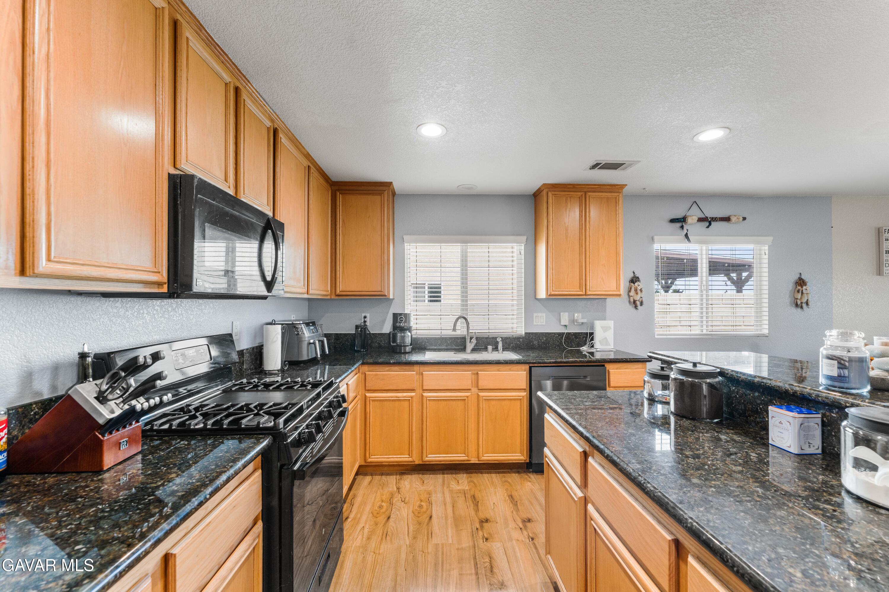 45448 Spahn Lane Lancaster, CA 93535 - Photo 13 of 49 a kitchen with stainless steel appliances granite countertop a sink stove and cabinets