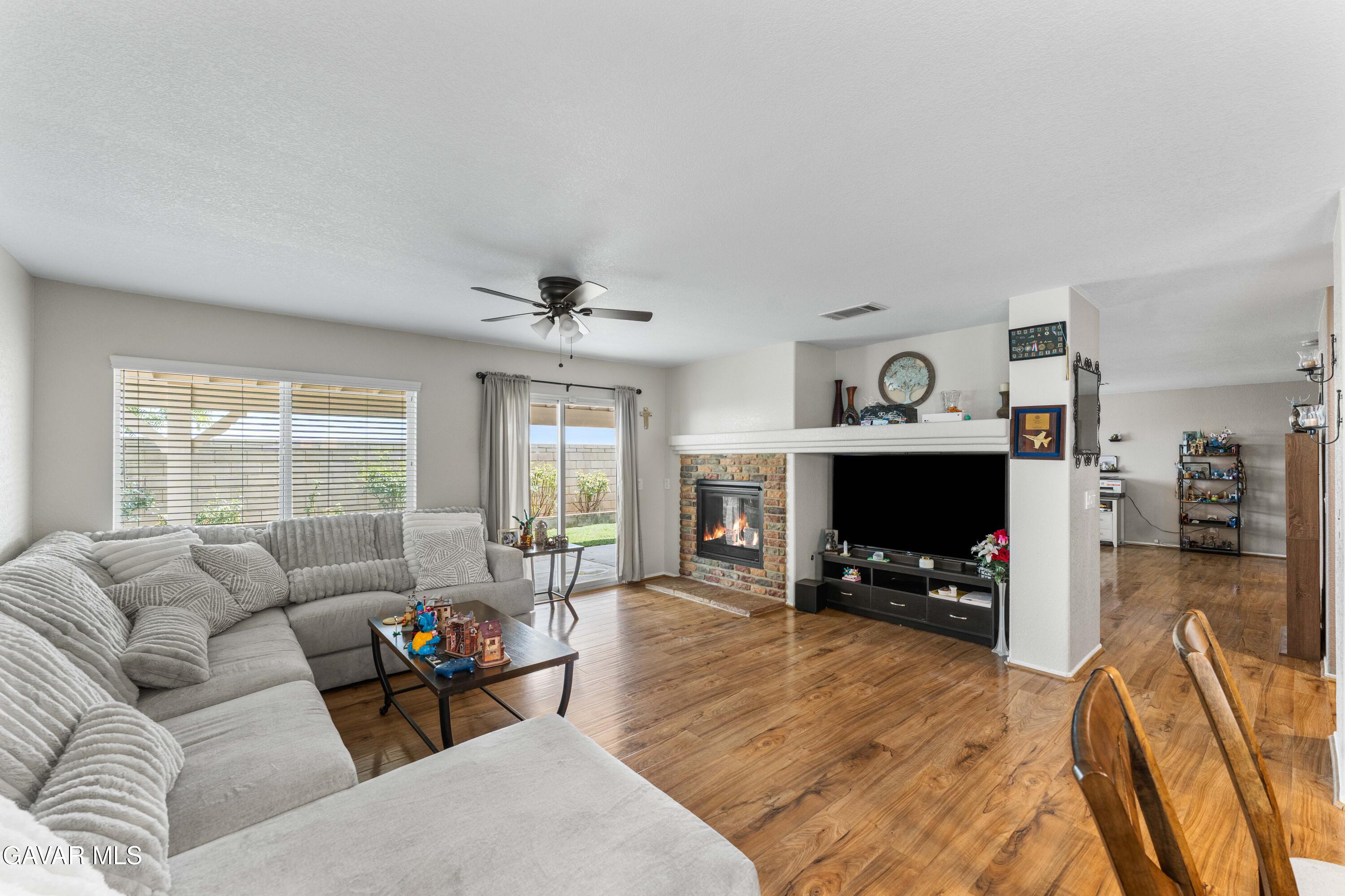 45448 Spahn Lane Lancaster, CA 93535 - Photo 3 of 49 a living room with furniture a flat screen tv and a fireplace
