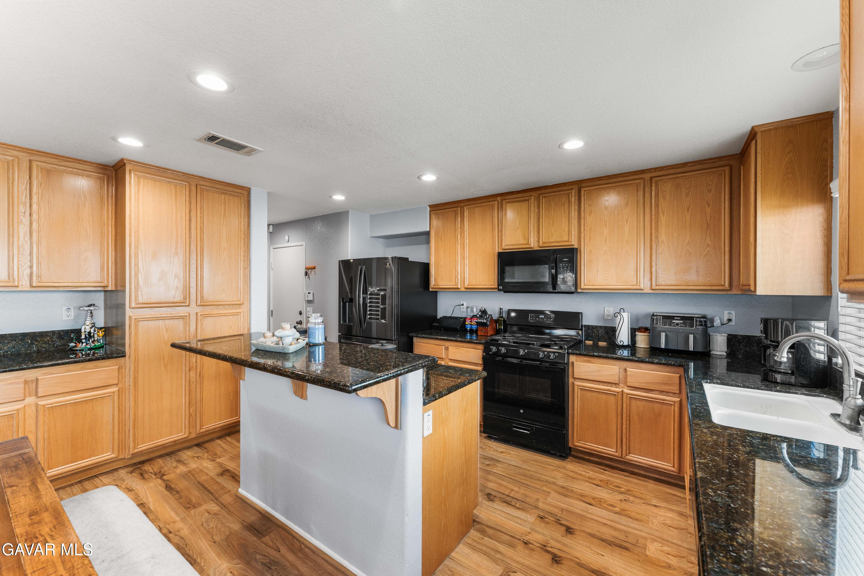 45448 Spahn Lane Lancaster, CA 93535 - Photo 10 of 49 a kitchen with stainless steel appliances granite countertop a stove a sink and a refrigerator
