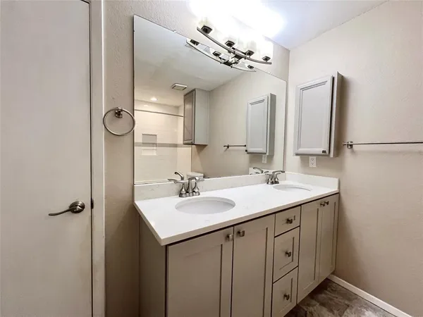 an empty room with a chandelier fan and windows