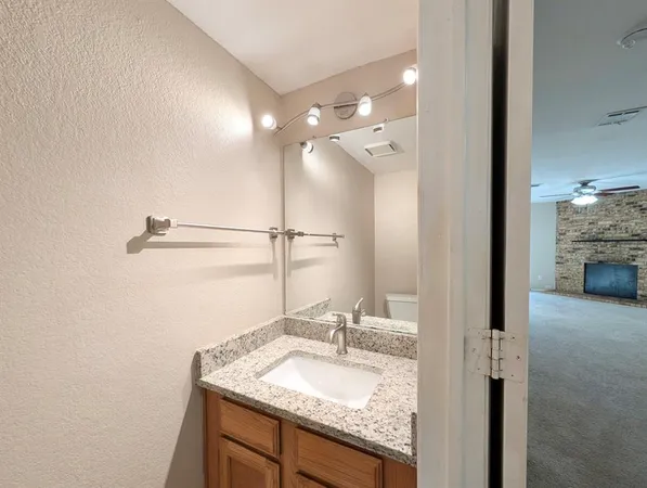 a bathroom with a granite countertop sink and a mirror