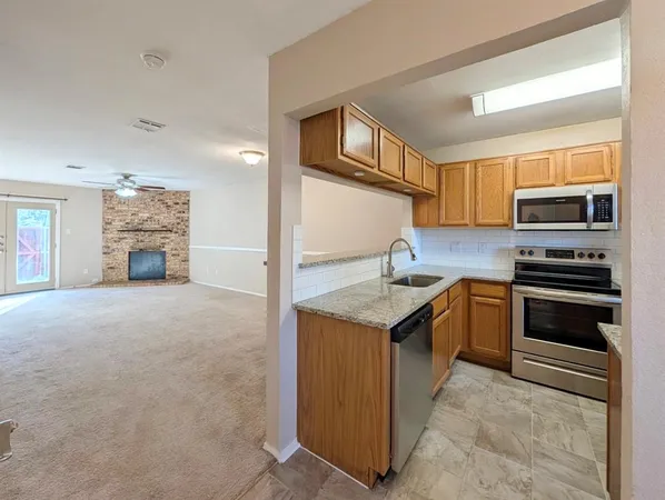 a kitchen with granite countertop a sink stove and cabinets