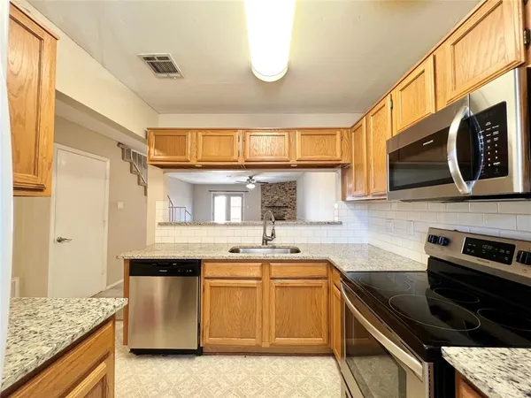 a kitchen with stainless steel appliances granite countertop a sink stove and cabinets