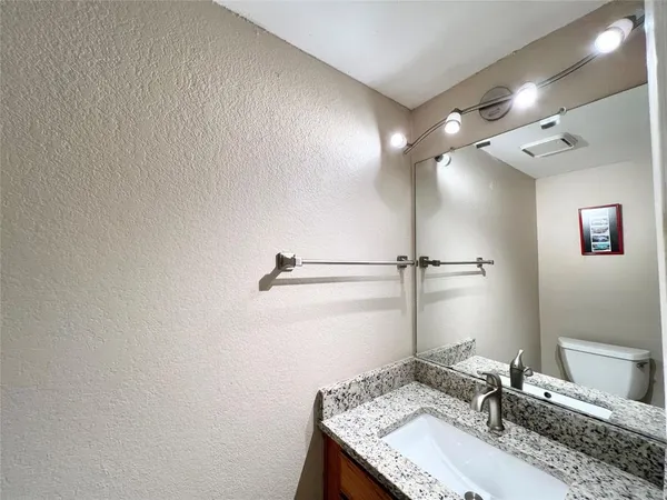 a bathroom with a granite countertop sink and a mirror