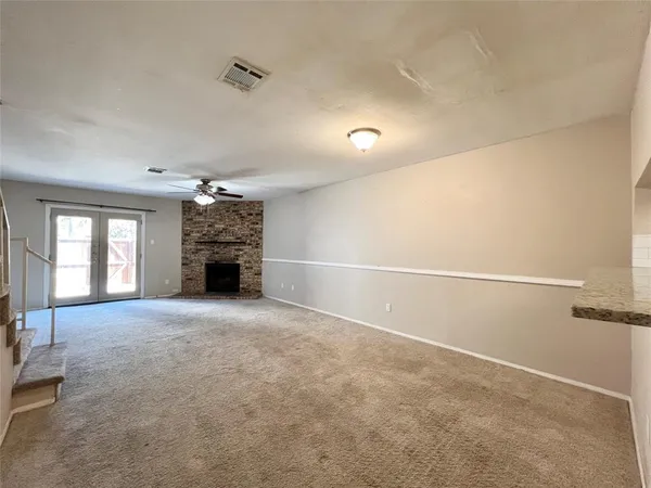 an empty room with windows and fireplace