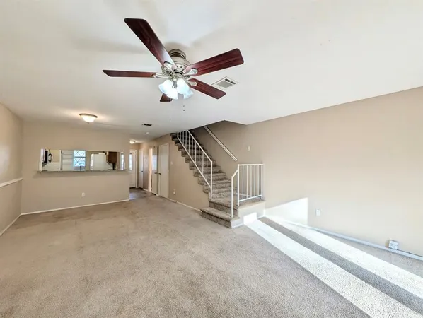a view of a livingroom with a ceiling fan and window