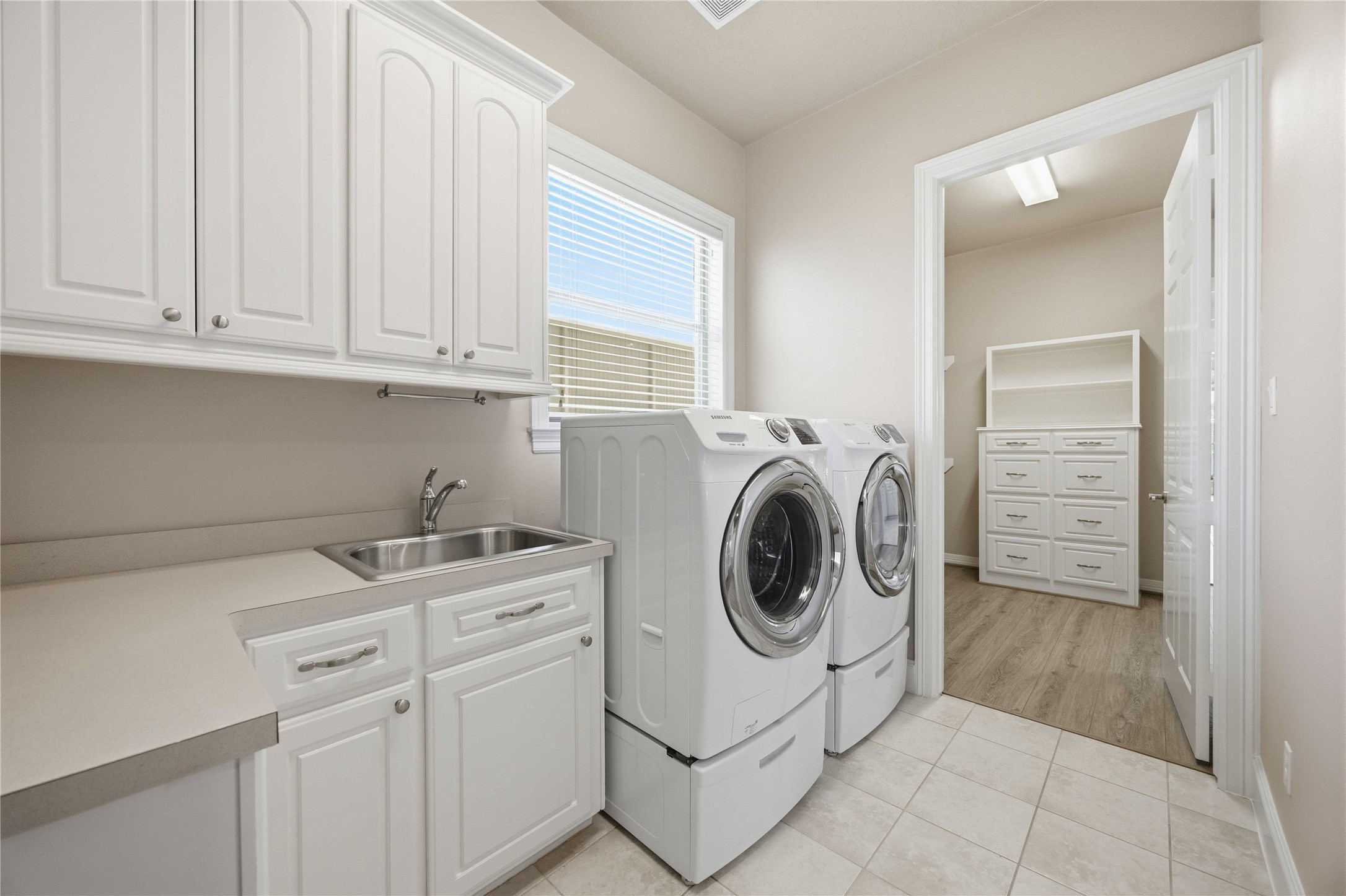 1930 Old River Road Montgomery, TX 77356 - Photo 19 of 49 The beauty of this utility room is that the back connects to the primary closet! Talk about convenient! The utility has space for a full-sized washer and dryer. Additionally, you'll love the counter space for folding and sorting, the cabinets for storage, and a sink for delicate clothes that require hand washing.