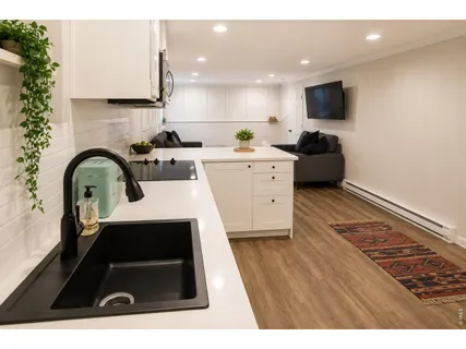 a living room with furniture a flat screen tv and kitchen view