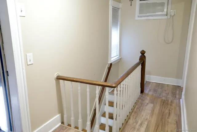 a view of staircase with railing and white walls