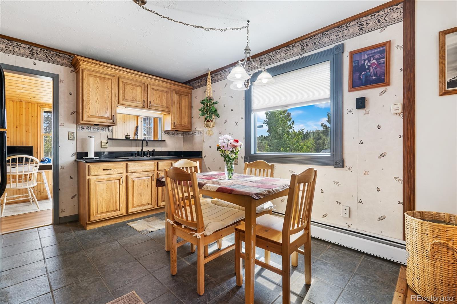 11948 Apache Trail Conifer, CO 80433 - Photo 18 of 45 a kitchen with a table chairs refrigerator and cabinets
