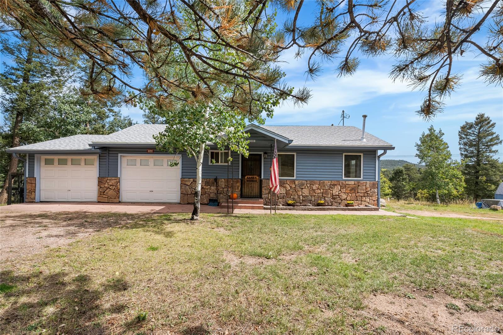 11948 Apache Trail Conifer, CO 80433 - Photo 41 of 45 a front view of a house with a garden and trees