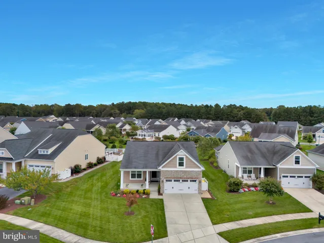 an aerial view of residential houses with outdoor space and trees