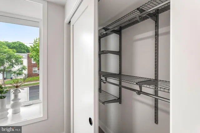 a view of walk in closet with window and glass door