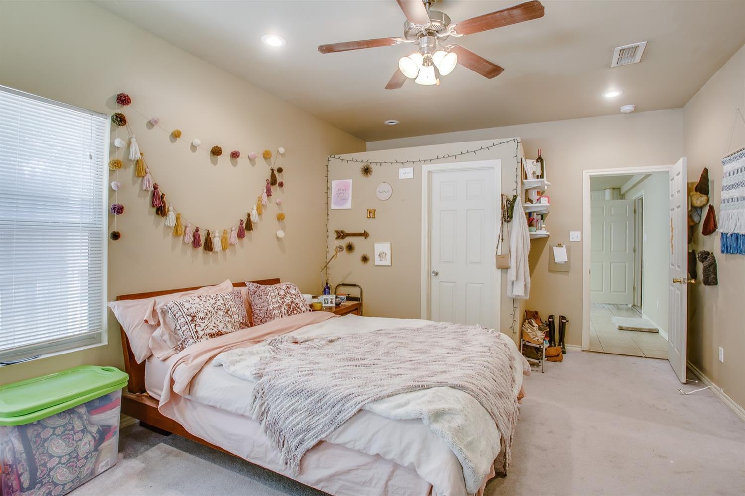 3114 30th Street Lubbock, TX 79410 - Photo 6 of 19 a bedroom with a bed and a chandelier