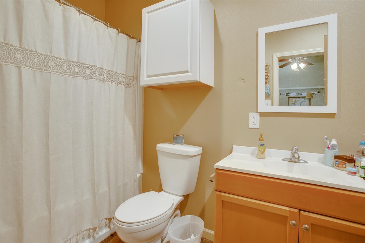 3114 30th Street Lubbock, TX 79410 - Photo 7 of 19 a bathroom with a toilet a sink and a mirror