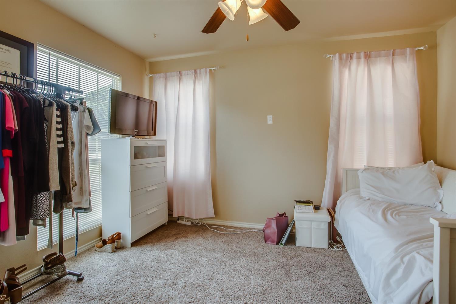 3114 30th Street Lubbock, TX 79410 - Photo 9 of 19 a bedroom with bed and a flat tv screen