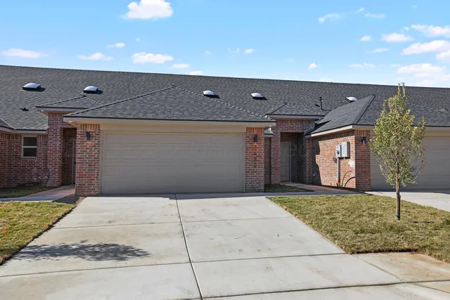 a view of a brick house with a garage