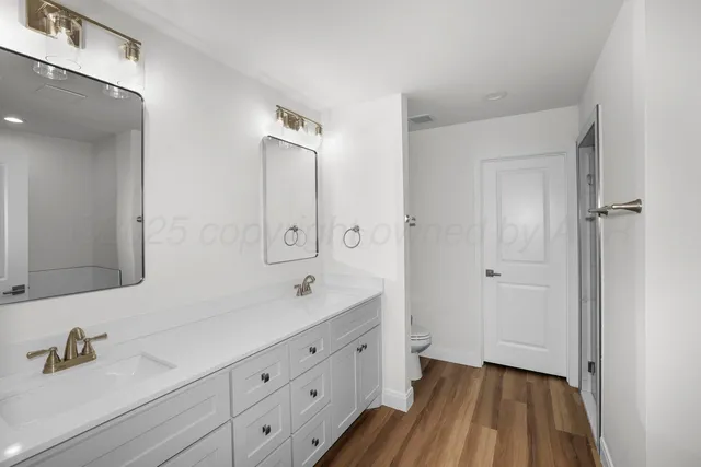 a spacious bathroom with a double vanity sink and mirror