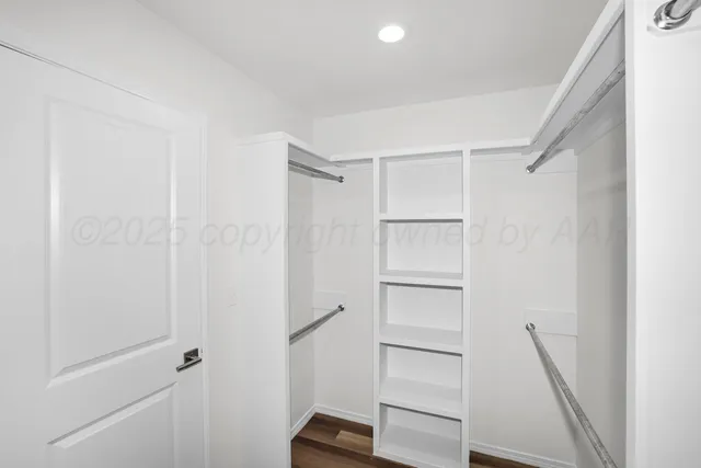 a view of walk in closet with empty racks