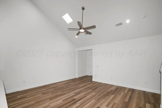 a view of a room with a ceiling fan and wooden floor